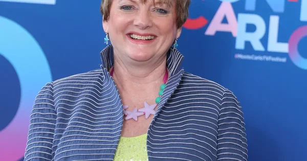 Alison Arngrim en mai 2010 tenant son livre Confessions of a Prairie Bitch, portant un haut noir à motifs.