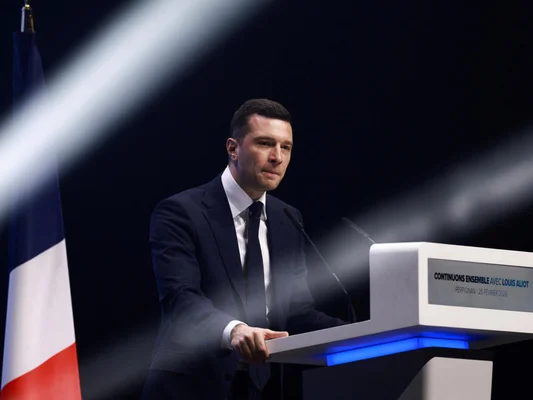 Louis Aliot lors d'un meeting à Perpignan devant un drapeau français.