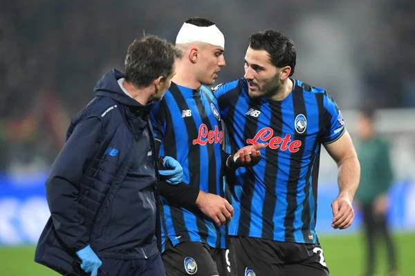 Des joueurs de l'Atalanta, dont Nikola Krstovic, échangent avec le staff médical sur le terrain.