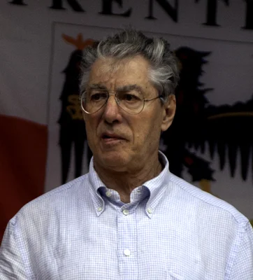 Umberto Bossi en chemise à carreaux devant un public.