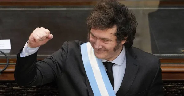 Javier Milei avec l'écharpe présidentielle, le poing levé en signe de célébration.