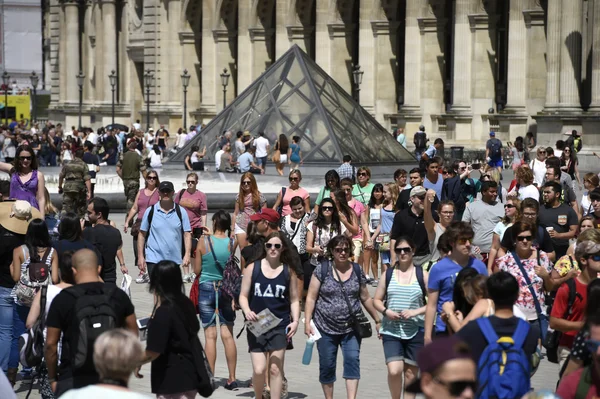 La cour Napoléon du Louvre bondée de touristes devant la pyramide.