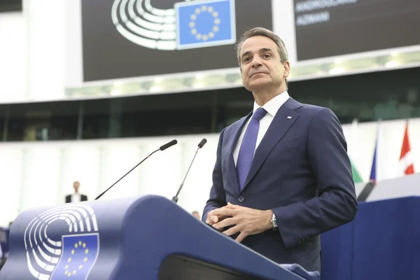 Un homme en costume debout à un podium du Parlement européen lors d'une conférence de presse.