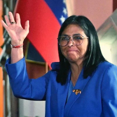 La présidente par intérim Delcy Rodriguez portant un costume bleu et des lunettes