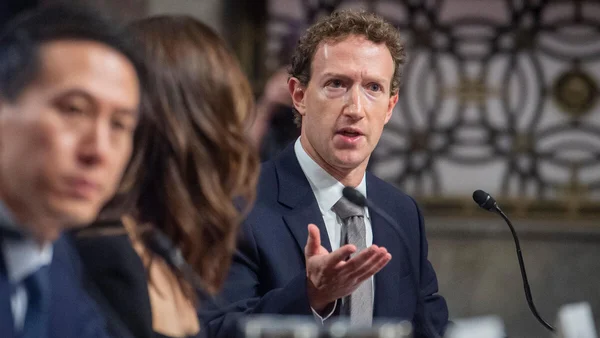 Une femme tenant une photo encadrée devant l'entrée du palais de justice des États-Unis.