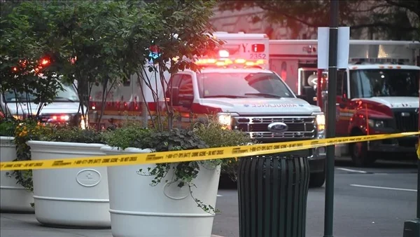 Ambulance et véhicules d'urgence derrière un ruban de police dans une rue.