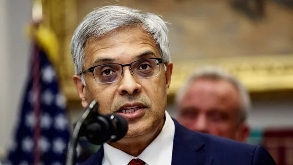 Le directeur des NIH, Jay Bhattacharya, s'exprime devant un drapeau américain.