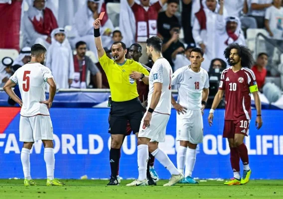 Arbitre brandissant un carton rouge lors d'un match de qualification pour la Coupe du monde.
