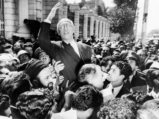 Un homme est porté par une foule en signe de soutien ou de protestation.