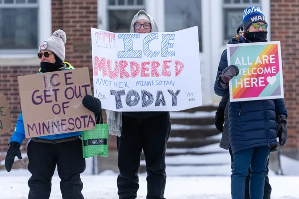 Membres de la communauté tenant des panneaux lors d'une veille publique protestant contre l'ICE à Brainerd.