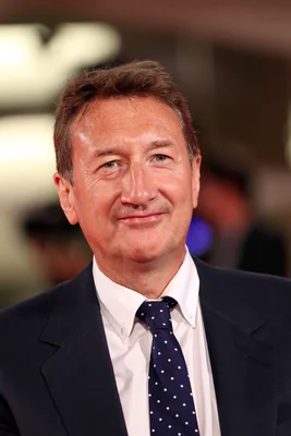 Steven Knight posant en costume et cravate lors d'une séance photographique professionnelle.