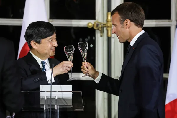 Deux responsables trinquant au champagne lors d'une réception officielle franco-japonaise.