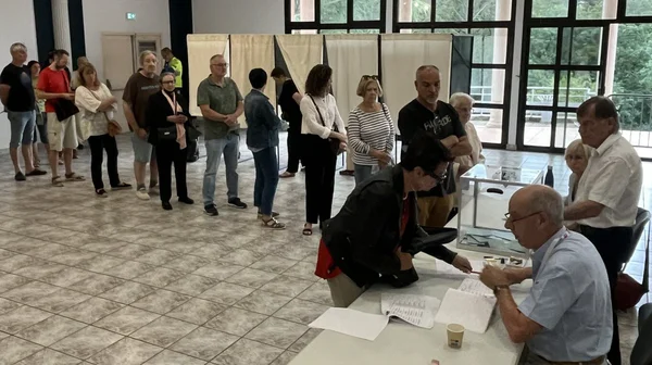 Une longue file d'électeurs attendant de voter à l'intérieur d'un bureau de vote.