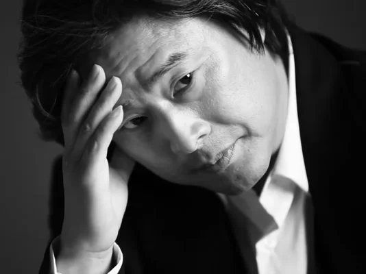 Photographie noir et blanc de Park Chan-wook lors d'un shooting pour Marie Claire Korea.