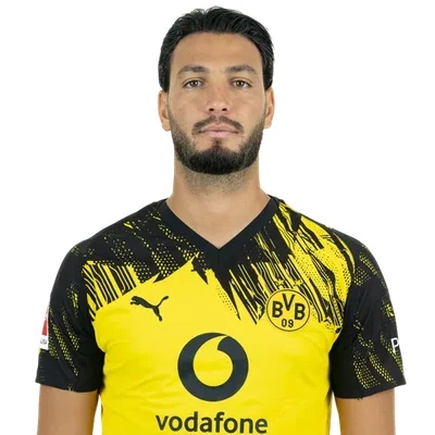Ramy Bensebaini en maillot du Borussia Dortmund posant sur fond blanc.