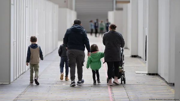 Une famille de réfugiés syriens dans un couloir d'un bâtiment institutionnel en Allemagne.