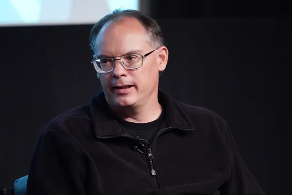 Tim Sweeney, le PDG d'Epic Games, dans un lieu sombre lors d'un événement médiatique.