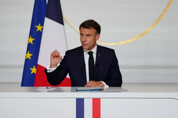 Emmanuel Macron s'exprimant depuis son bureau devant les drapeaux de l'Union européenne et de la France.