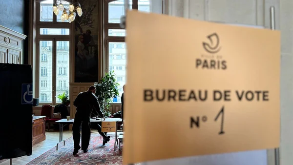 Intérieur d'un bureau de vote à Paris identifiable par le panneau 'BUREAU DE VOTE N°1'.