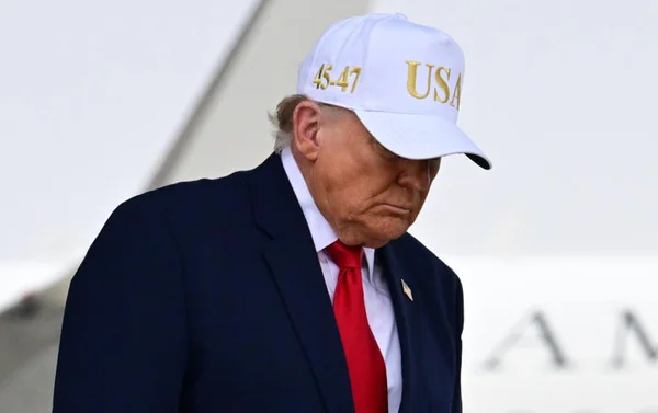 Un homme portant la casquette MAGA dans la Situation Room aux côtés d'un conseiller en costume devant le sceau du président.