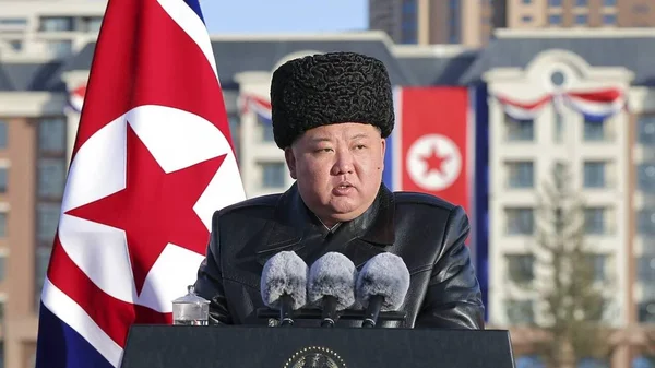 Kim Jong-un s'exprime devant des bâtiments décorés aux couleurs de la Corée du Nord.