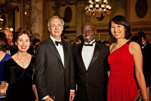 Ray Dalio et sa femme, entourés d'autres invités, lors d'une réception élégante.