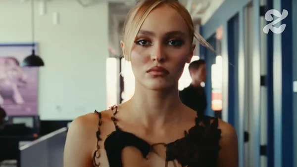 Lily-Rose Depp en haut en dentelle noire dans un environnement de bureau