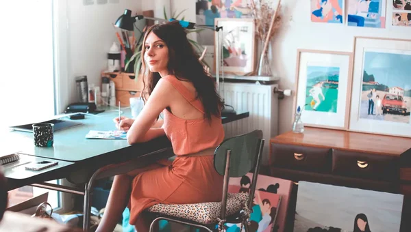 Marie Baudet à son bureau dans son atelier lumineux et artistique.