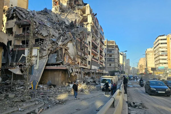 Bâtiment partiellement effondré et éparpillement de ruines sur une rue de Beyrouth.
