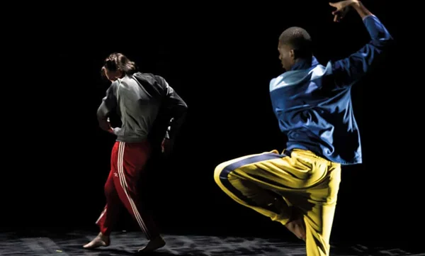 Deux danseurs interprétant une chorégraphie dynamique lors d'un événement PSPBB au Café de la Danse.