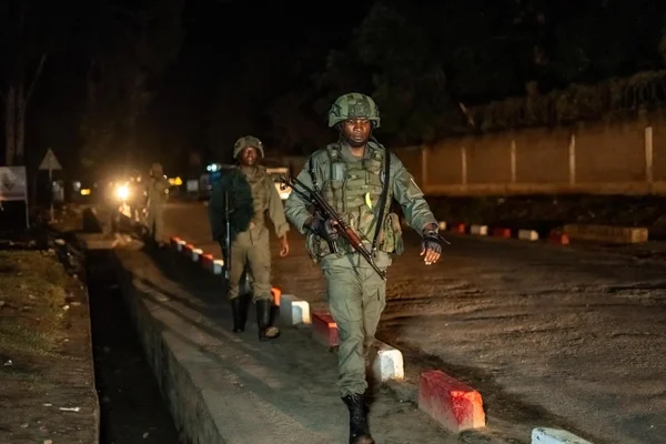 Des soldats patrouillant sur une route d'Uvira la nuit.