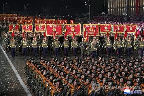 Des soldats portant des bannières rouges défilent de nuit lors du congrès du Parti du travail.