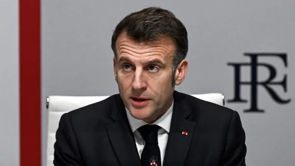 Un responsable français assis devant un fond aux couleurs de la République.