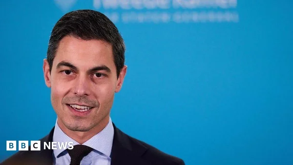 Rob Jetten en costume et chemise rayée devant un fond bleu de la BBC.