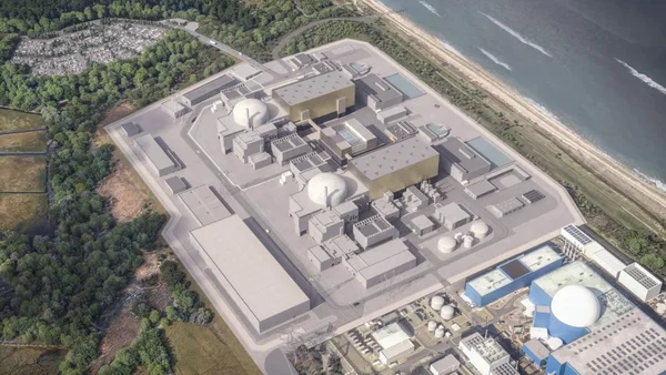 Vue aérienne d'une grande centrale nucléaire moderne avec deux réacteurs cylindriques en forme de dôme et des tours de refroidissement dégageant de la vapeur blanche, entourée d'une végétation verdoyante sous un ciel bleu dégagé