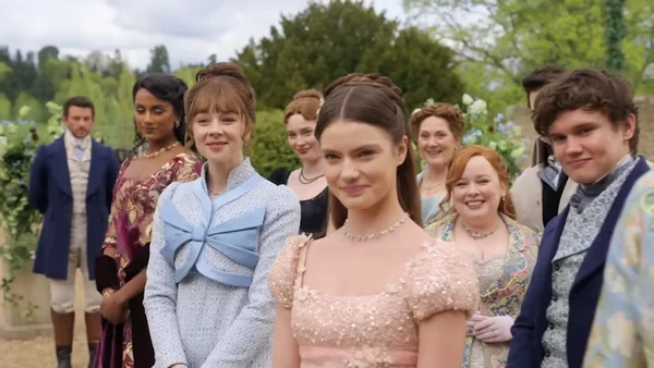 Distribution de la saison 5 en costumes dans un jardin, figure centrale en robe rose.