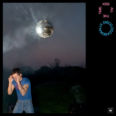 HarryStyles debout sous un disco ball lors d'une soirée.