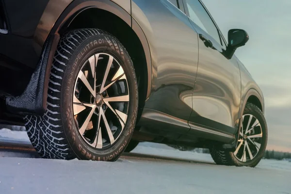 Le pneu hiver Nokian Hakkapeliitta 01 à clous rétractables automatiquement, monté sur un SUV argenté sur la neige.