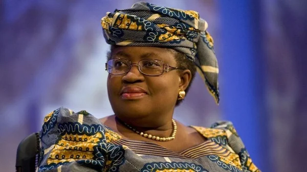 Portrait de Ngozi Okonjo-Iweala en tenue bleue à motifs et lunettes.