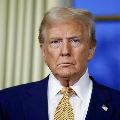 Portrait de Donald Trump portant un costume bleu foncé, une chemise blanche et une cravate à motifs dorés.