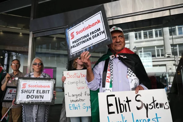 Manifestants avec des pancartes critiquant Scotiabank et Elbit Systems lors d'une manifestation