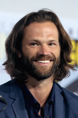 Jared Padalecki posant en costume bleu marine.