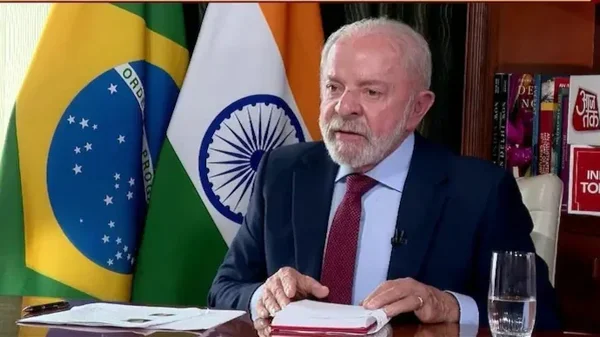 Le président Lula assis à un bureau, avec les drapeaux du Brésil et de l'Inde en arrière-plan.
