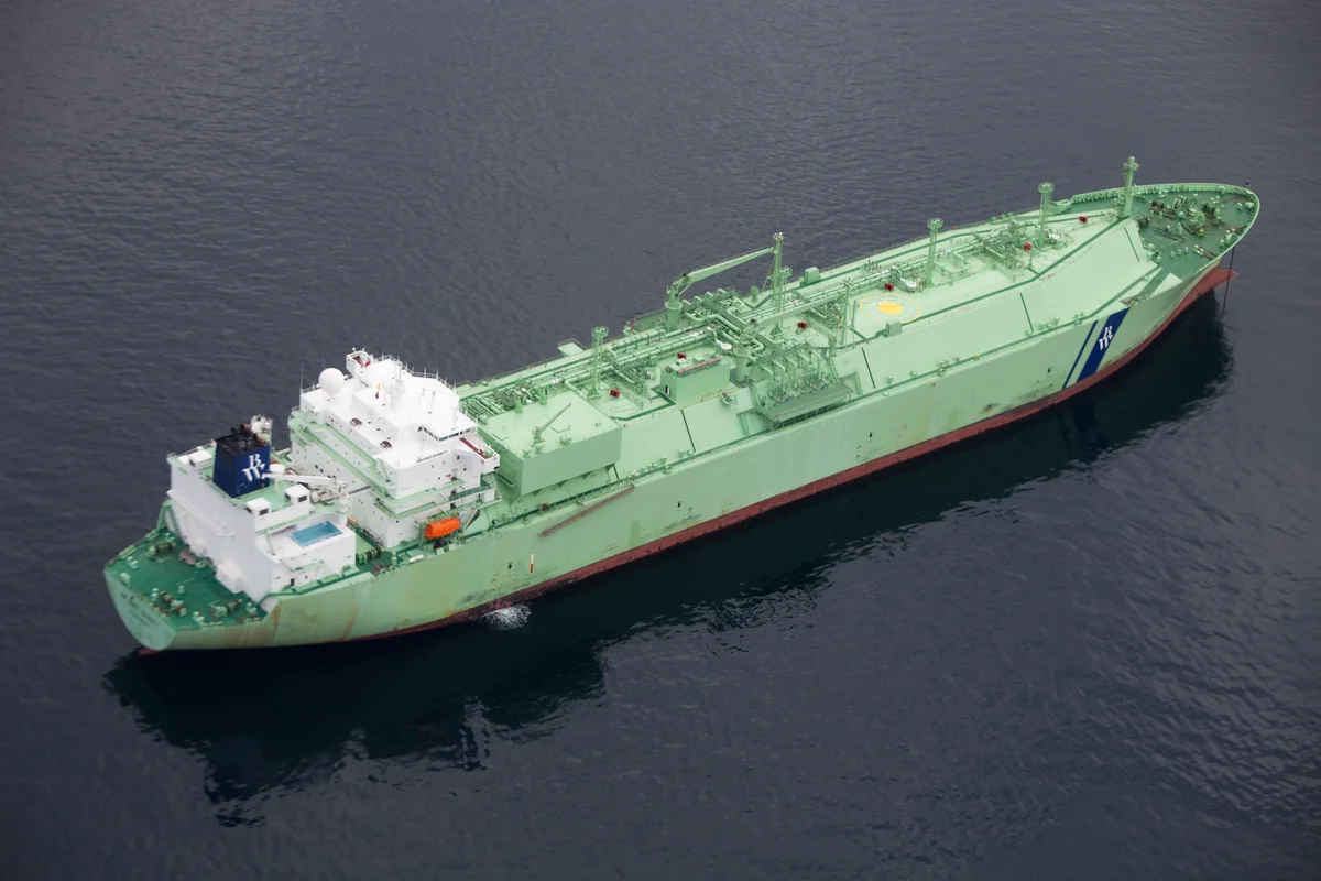 Le navire MT Arctic Metagaz, grand cargo vert avec une superstructure blanche, flottant sur l'eau sombre.