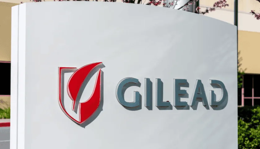 Panneau d'entreprise Gilead Sciences installé à l'extérieur, avec des bâtiments flous en arrière-plan.