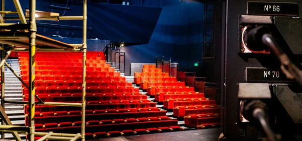L'intérieur du théâtre avec ses rangées de sièges et des équipements techniques visibles.