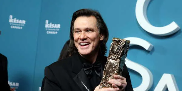 Jim Carrey tenant une statuette aux César.