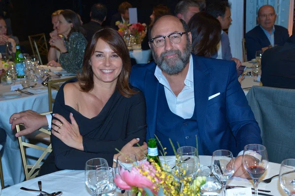 Kad Merad et Julia Vignali assis à une table lors d'un dîner.