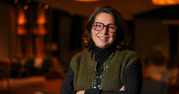 Marina Ferrari souriante lors d'un événement intérieur.