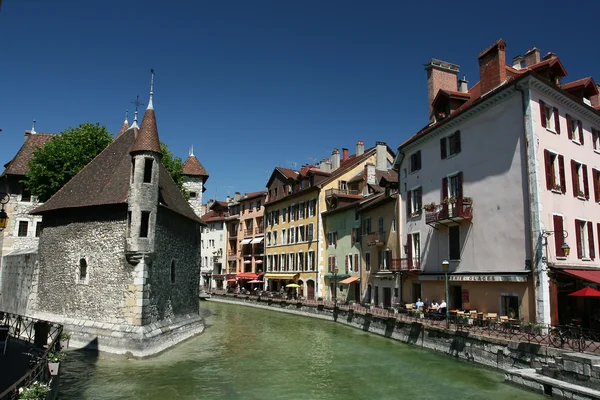Le Palais de l'Isle et le Thiou à Annecy, bâtiments historiques le long du canal sous un ciel bleu.